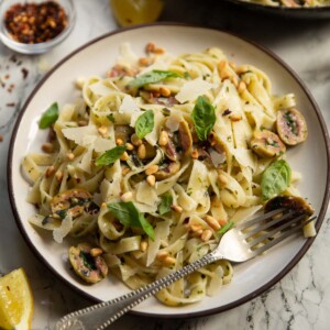 olive pasta served on small white plate with silver fork